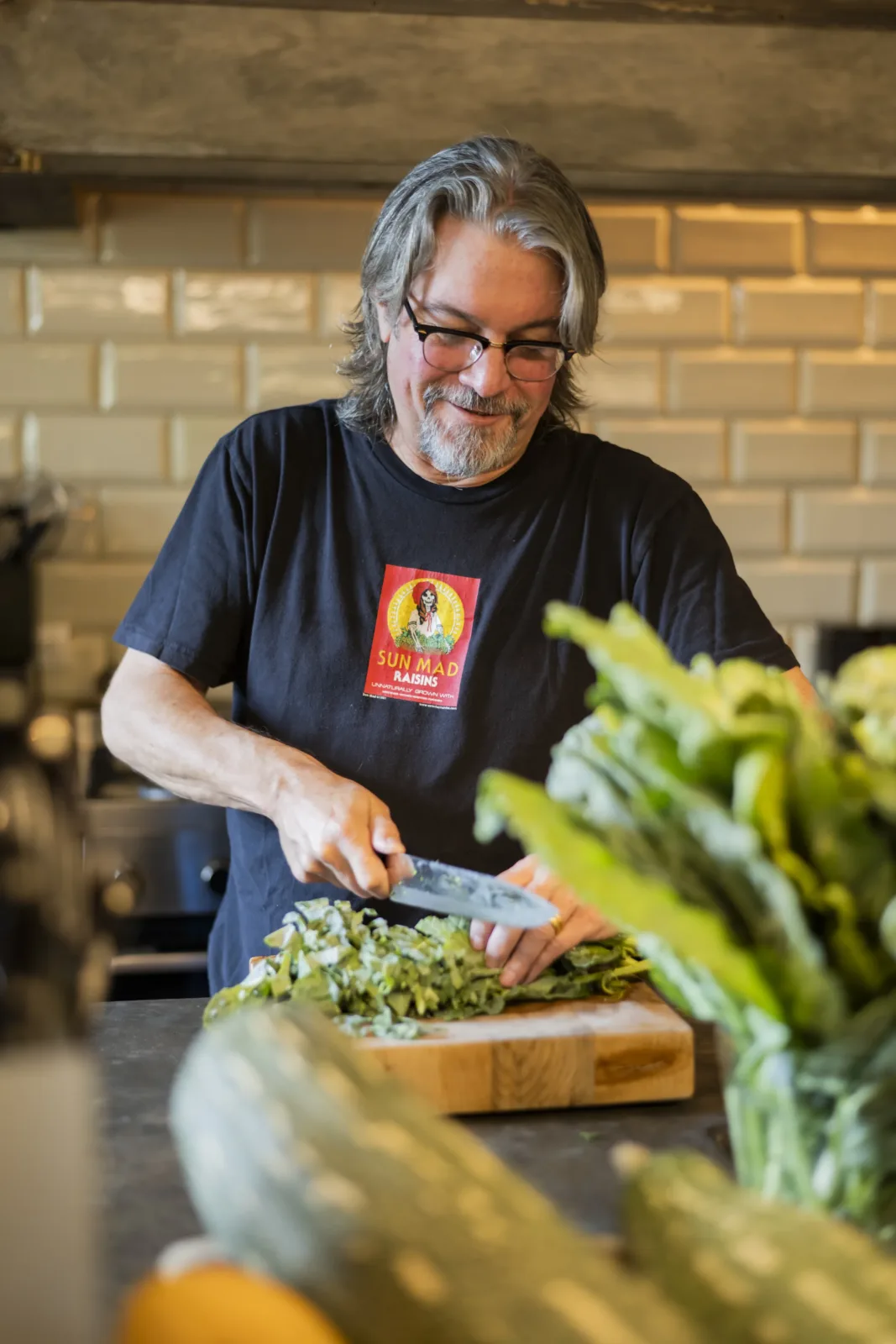 Jim in the kitchen, with what came in from the garden that morning.